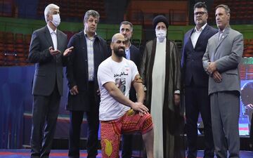 آیت‌الله رئیسی بازوبند پهلوانی را بر بازوی جابر صادق‌زاده بست