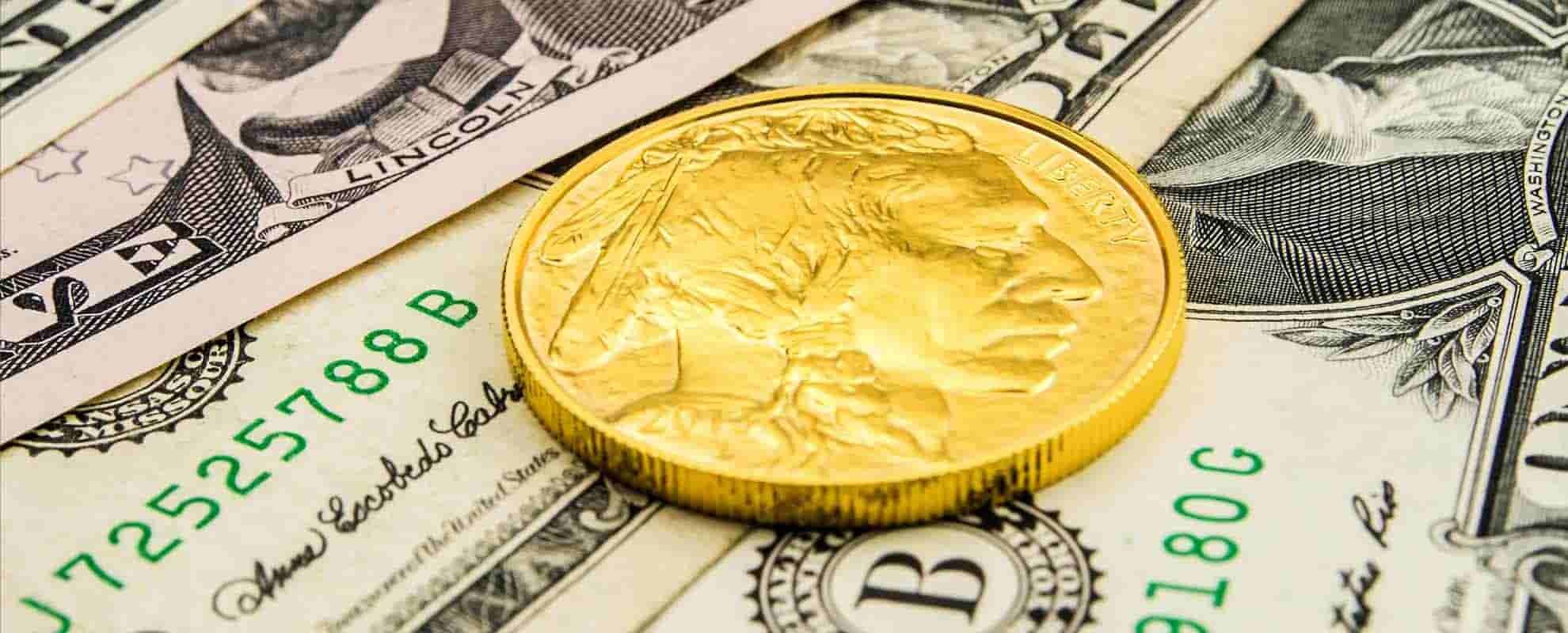 یک سکه طلا روی اسکناس‌های دلار
